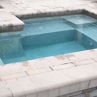 swimming pool with multiple levels and scuppers in lake county florida with stone accent